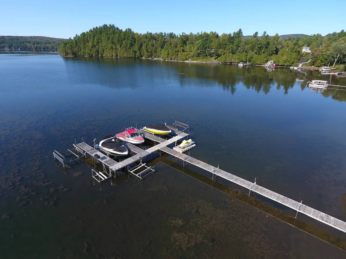 Aerial view of a long dock with a boat lift on a calm lake