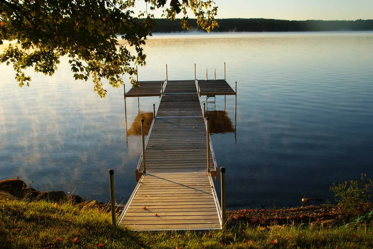 Quiet wooden dock reaching out onto a lake in early morning